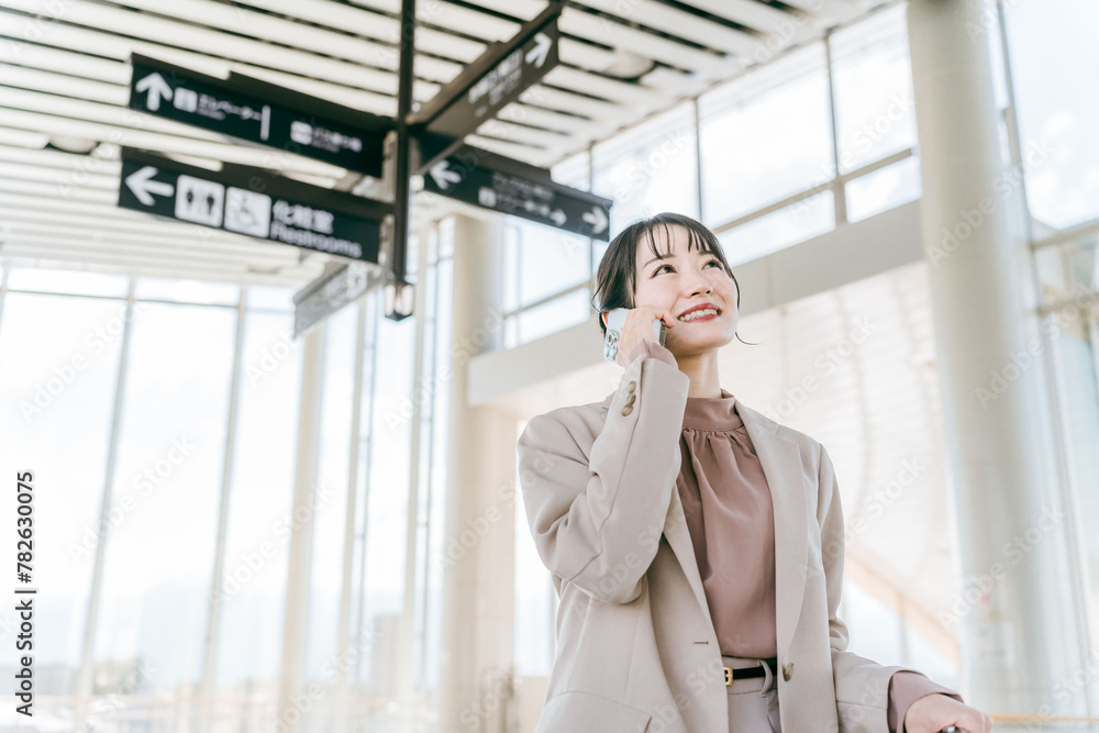 スマホで電話しながら空港・駅・ビル・公共交通施設でスーツケースを持って歩く女性(海外出張・徒歩)
スマホで電話しながら空港・駅・ビル・公共交通施設でスーツケースを持って歩く女性(海外出張・徒歩)