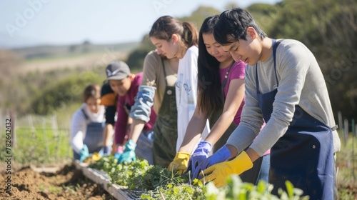 A group of students dons gardening gloves and aprons as they prepare to harvest seed from a nearby field ready to turn it into biofuel in a demonstration of sustainable farming practices. .