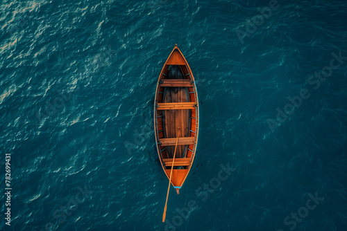 Aerial view of a solitary wooden boat on calm turquoise waters