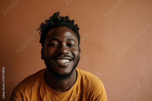 Young african american man in a yellow t-shirt smiling