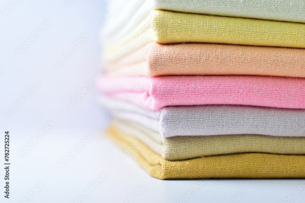 stack of colourful cotton clothes, pile of clothing on white background stack of colourful cotton clothes, pile of clothing on white background