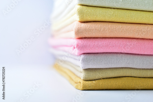 stack of colourful cotton clothes, pile of clothing on white background