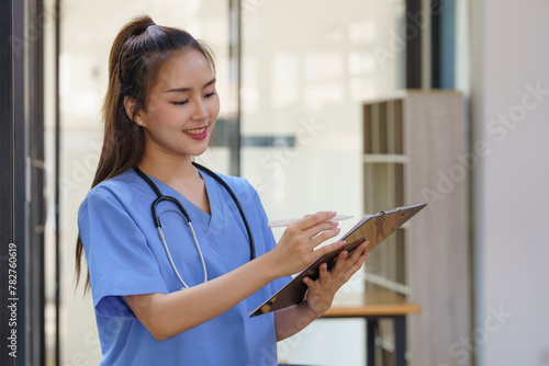 Asian female Doctors take note of information about patients in paperwork.