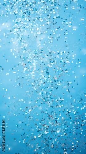 A shower of fine glitter sparkles on a serene blue background, creating a festive mood