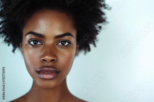 The portrait of young african woman looking at camera with confident and separated with white background, an attractive beautiful american african girl with afro hairstyle staring at a camera. AIGX01.