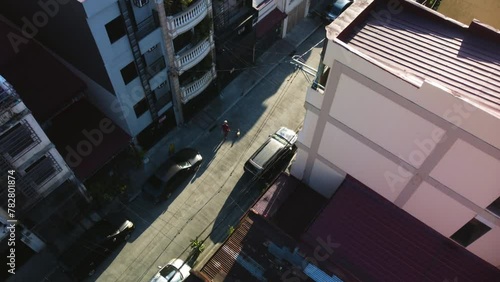 Drone tracking people in the suburbs of Makati city, sunny day in Manila, Philippines photo