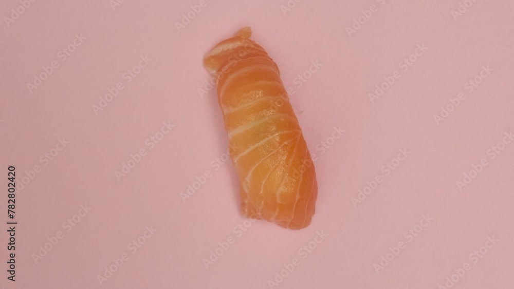 Sushi roll rotating on rosy background Sushi roll rotating on rosy background