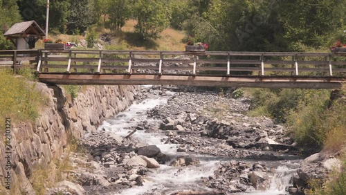 Wallpaper Mural Wooden Bridge Over Alpine Torrent Flowing Through Alps Landscape In The Summer. - wide shot Torontodigital.ca