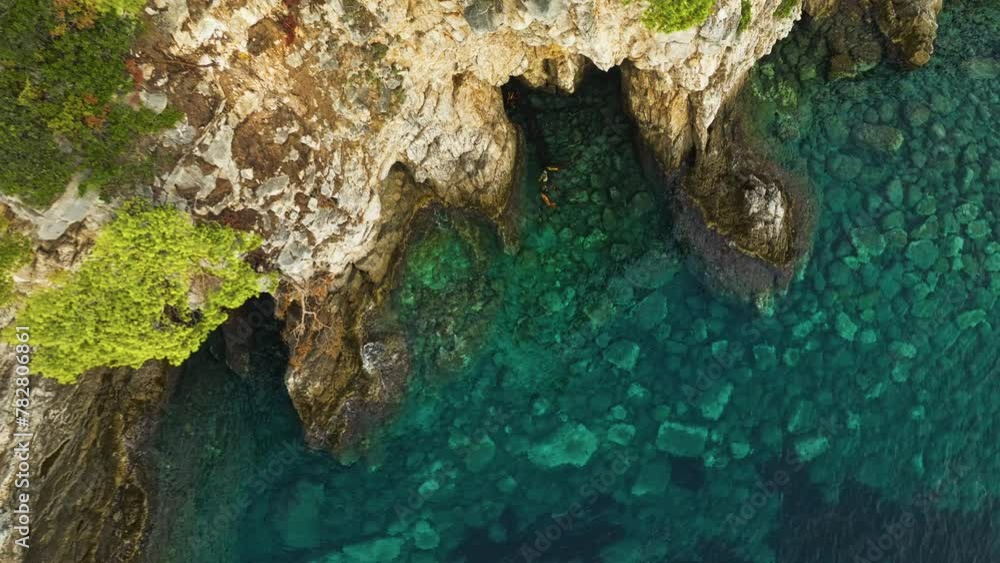 Kalamota Island, Adriatic Sea, Croatia - The Serene Blue Waters Contrasted by the Rugged Shoreline Beneath the Vegetation-covered Cliffs - Pullback Ascend Shot Kalamota Island, Adriatic Sea, Croatia - The Serene Blue Waters Contrasted by the Rugged Shoreline Beneath the Vegetation-covered Cliffs - Pullback Ascend Shot