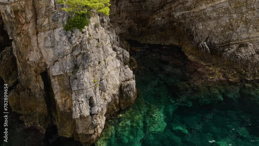 Kalamota Island, Adriatic Sea, Croatia - The Untouched Azure Waters Close to the Steep and Rugged Cliffs - Pan Up Shot