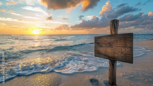 Sunset on the beach with waves washing over a wooden signpost photo