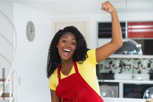 Portrait of  motivated african american au pair with apron at kitchen