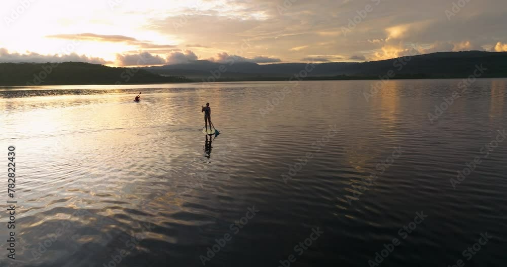 People Standup Paddleboarding And Kayaking On The Ocean At Sunrise On Moso Island In Vanuatu. drone pullback shot People Standup Paddleboarding And Kayaking On The Ocean At Sunrise On Moso Island In Vanuatu. drone pullback shot
