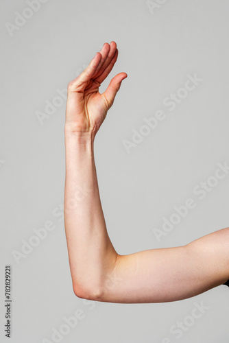 Close-Up of a Human Arm Extended Against a Plain Background