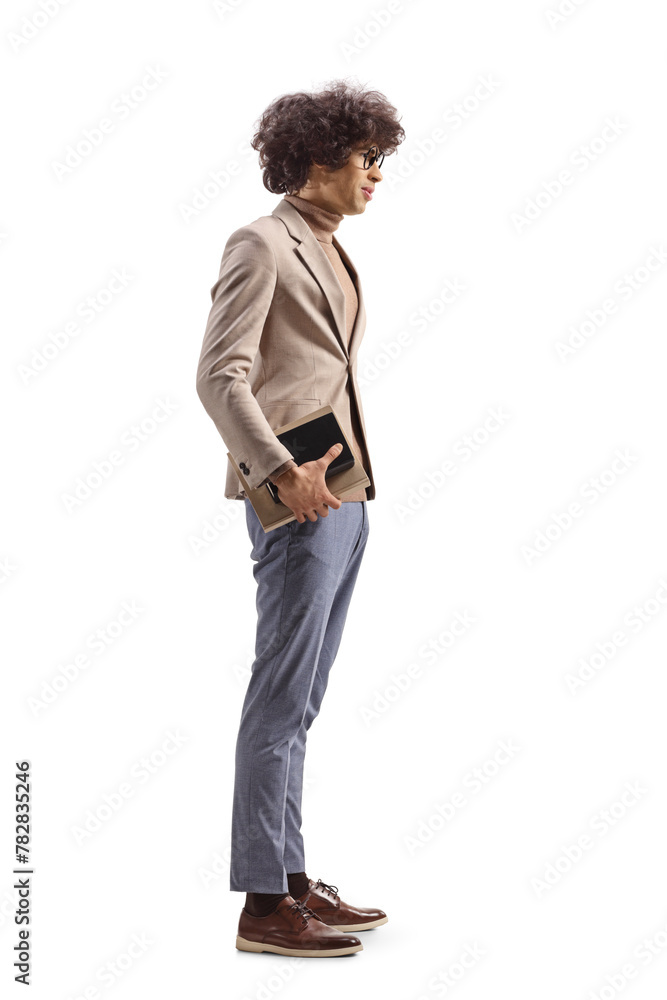 Full length profile shot of a young slim man holding a book Full length profile shot of a young slim man holding a book