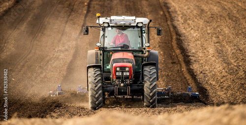 Powerful tractor with plow in action, turning the rich soil for new crops