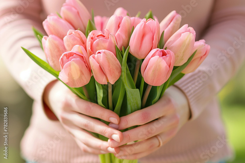 Pink tulips in woman's hands. Mother's Day background. Created with Generative AI technology.