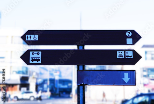 Dark brown wooden track pointer or station Background is blurred city. collection of various empty wooden sign or symbol. Wooden signs provide directions for travelers to reach their goals.