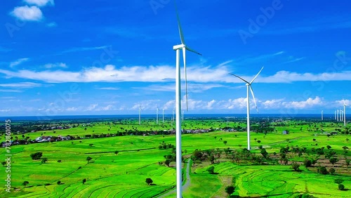 Aerial view of a wind turbine farm with rice paddies and a beautiful sky photo