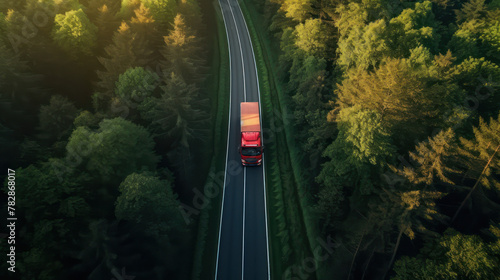 Red Wagon truck driving on the highway, aerial shot over forest. Transport logistics background.