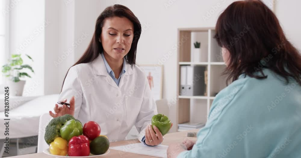 nutritionist doctor consulting overweight patient, providing advice on healthy eating plan and creating a diet program. They discussing the importance of including vegetables in the diet. nutritionist doctor consulting overweight patient, providing advice on healthy eating plan and creating a diet program. They discussing the importance of including vegetables in the diet.