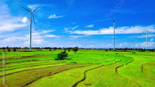 Aerial view of a wind turbine farm with rice paddies and a beautiful sky photo