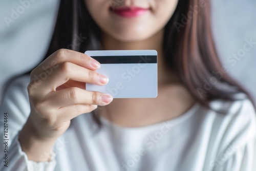A young woman holding a credit card in her hand and suggesting that she may be shopping or socializing. Fictional Character Created by Generative AI. photo