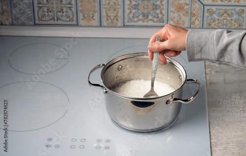 Cooking rice in a saucepan on an electric stove.