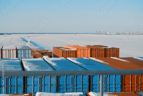 Container Ship Sailing Underway In The Frozen International Shipping Fairway Route. Water Surface Covered With Ice. Winter Navigation in The Arctic Area Region. photo