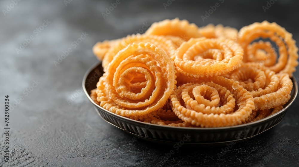 Fototapeta premium Closeup Image of a Bowl Filled with Indian Snack Chakli Placed on Surface, Ready to be Eaten.