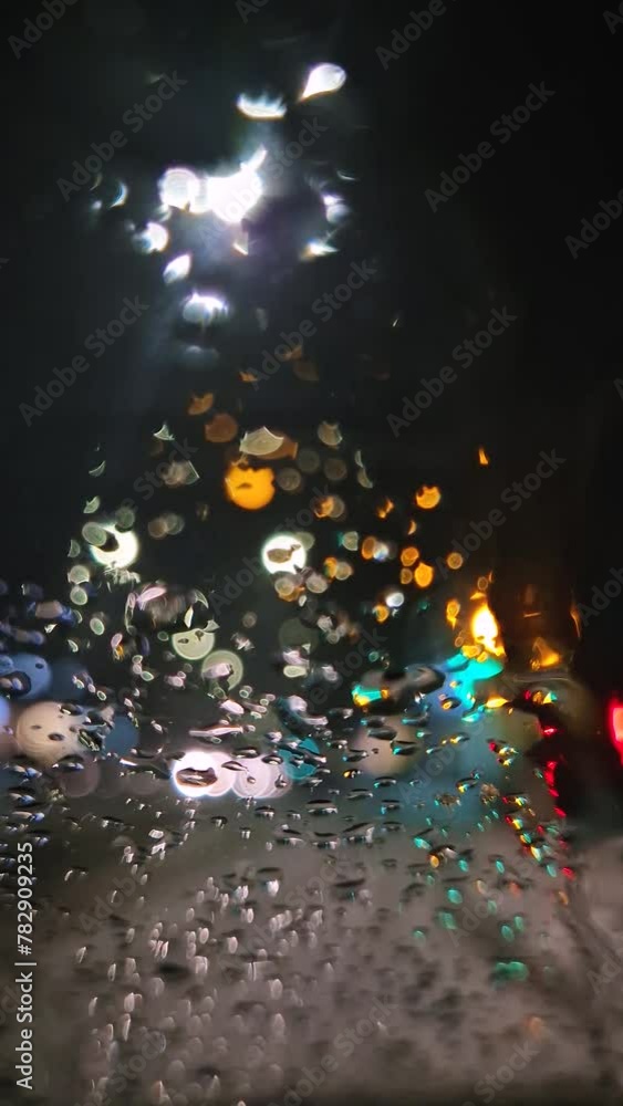 Urban night traffic scene as seen through the vehicle window covered with water drops. Melting snow and sleet drips on the car windshield
Urban night traffic scene as seen through the vehicle window covered with water drops. Melting snow and sleet drips on the car windshield