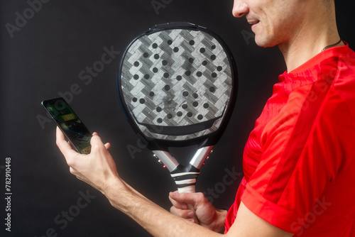 man holding paddel racket and smartphone photo