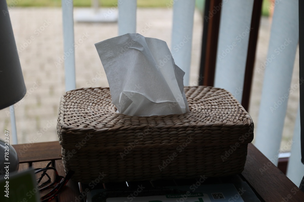 Straw box for napkins laid on a table Straw box for napkins laid on a table