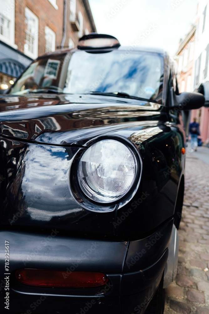 Vertical shot of a vintage black car details on the street