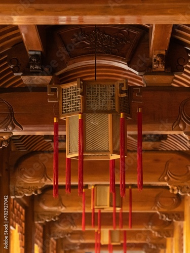 Vertical shot of a lantern hanging from a roof in the Faxi Temple in Hangzhou, China photo