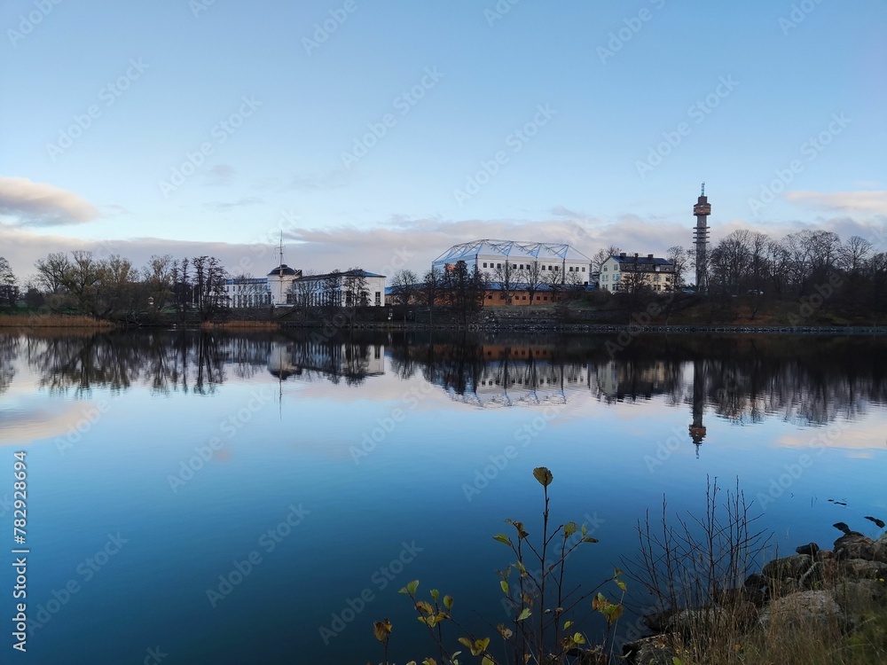 Scenic landscape of a lake surrounded with buildings with a colorful and cloudy sky