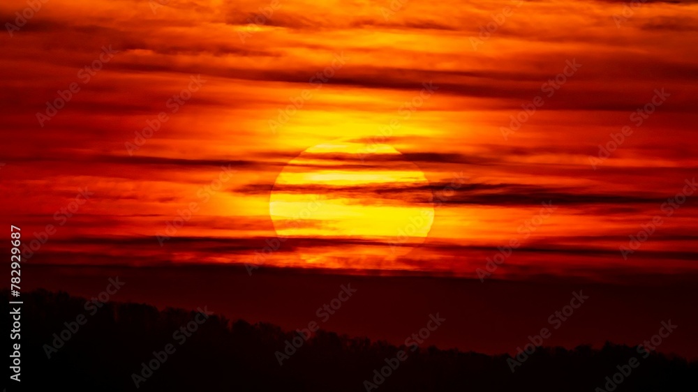 Beautiful view of a setting sun in a red-illuminated sky, can be used for wallpaper