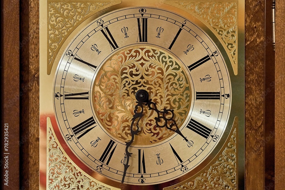 Antique golden clock with roman numerals and black hands