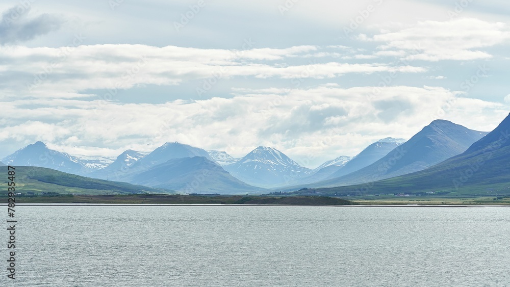 Snowcap mountain range from the lake on cloudy sky background in Iceland Snowcap mountain range from the lake on cloudy sky background in Iceland