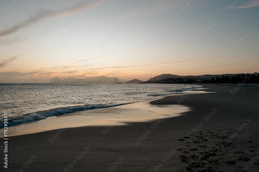 Beautiful shot of Camboinhas beach and sea with mountain in the background at sunset