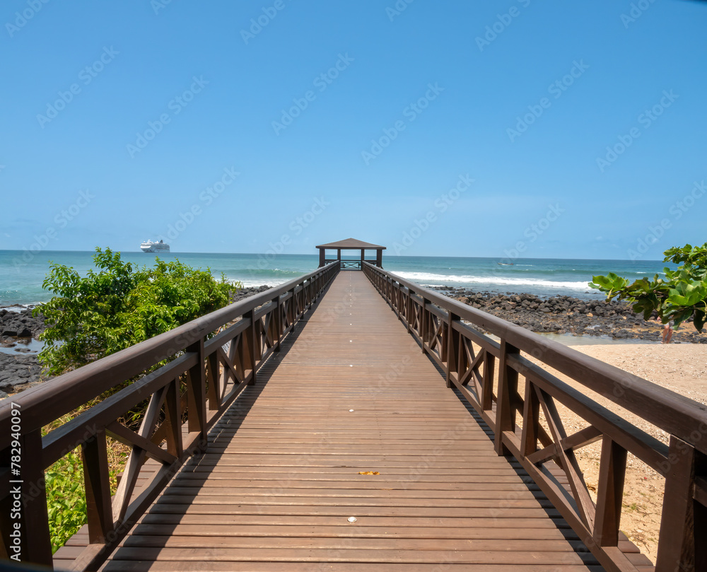 Boardwalk on a beach in São Tomé with a cruise ship in the background, São Tomé and Principe (STP), Central Africa