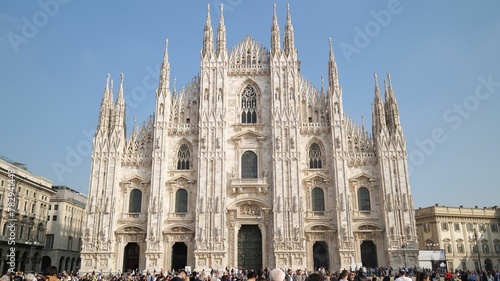 Piazza del Duomo surrounded by tourists under a blue sky in Milan, Italy photo