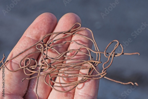 a coil of brown copper wire lies on the palm of the hand