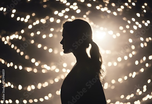 a woman standing in front of a ball of lights in the dark