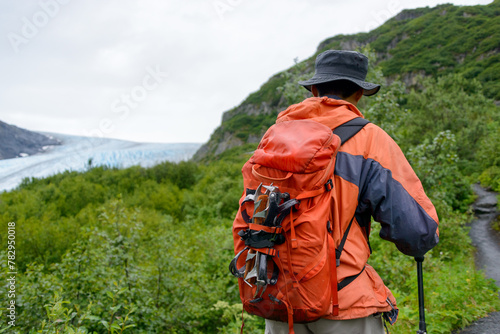Man carrying ice crampons on his backpack, hiking towards Exit Glacier.  Kenai Fjords National Park. Alaska.