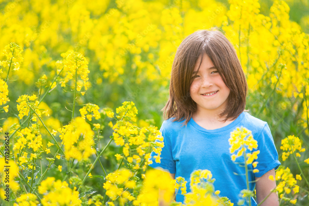 Smiling child among the flowers of a rapeseed field on a spring day. Smiling child among the flowers of a rapeseed field on a spring day.