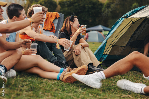 Group of friends raising beer cups, celebrating at a summer music festival photo