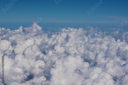Vast cloudscape with whte, fluffy clouds seen from above © Wirestock