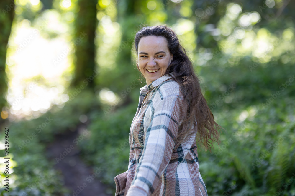 Young Woman smiling and Walking Down Path in Woods Young Woman smiling and Walking Down Path in Woods