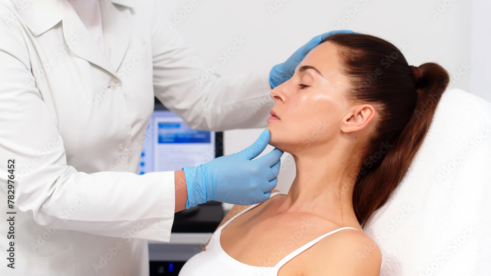 Naklejka premium A female cosmetologist-dermatologist talks to a client sitting in a comfortable salon chair. Consultant cosmetologist advises on the facial hydrolifting procedure. Professional inspection.